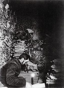 Archivo:Paul Pelliot examining manuscripts in Cave 17 at Mogao Caves in 1908