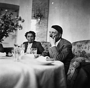 Archivo:Hitler sitting at a table