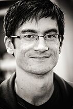 Dark-haired man with glasses smiling