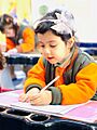 تلميذة تكتب بيدها اليسرى