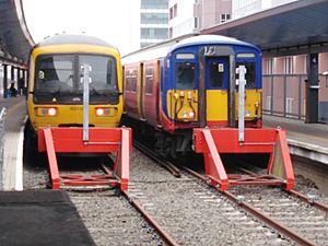 Archivo:British Rail Class 165 110 & 455 718 at Reading's third rail electrified platforms