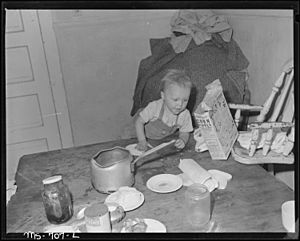 Archivo:Son of Charles B. Lewis, miner, playing around kitchen table in home in company housing project. Union Pacific Coal... - NARA - 540564