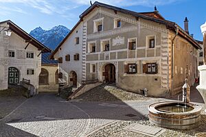 Archivo:Engadinerhaus und hölzener Brunnen in Guarda