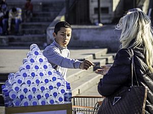 Archivo:Street transaction between boy selling water bottles and woman, Istanbul (13271945715)