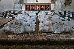 Sobre los almohadones se ven los escudos de las casas nobiliarias