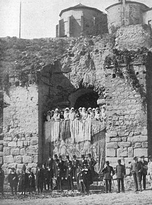 Archivo:1913-10-13, La Ilustración Artística, Toledo, Las autoridades y señoritas de la aristocracia esperando el paso de la comitiva en la antigua puerta de la Alcazaba (cropped)