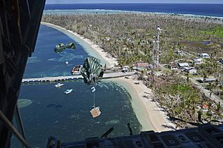 Cargo drops from a U.S. Air Force C-130 Hercules aircraft over the Pacific Ocean toward a landing zone on the shore of Kayangel Island during the 62nd annual Operation Christmas Drop Dec. 11, 2013 131211-F-NA975-171.jpg