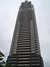 Ground-level view of one brown, rectangular facade of a high-rise