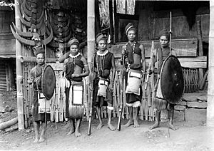 Archivo:COLLECTIE TROPENMUSEUM Een groep mannen van de Ngadastam in krijgskleding met lans klewang achterlaadgeweer en schild TMnr 10006045