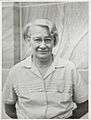 Dorothy Hill, later in life, standing before a sandstone wall