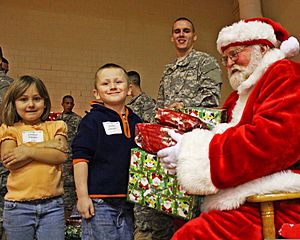 Archivo:Pvt. Evan Allen Dancer, center, smiles as Santa Claus, right, hands gifts to Destiny Hawley and her brother Justin Hawley of Scipio, Ind., during the 3rd Annual Operation Christmas Blessing event at Muscatatuck 111212-A-QU728-005