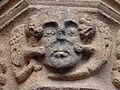 Cabeza de condenado infernal atacada por dos diablos en forma de dragones