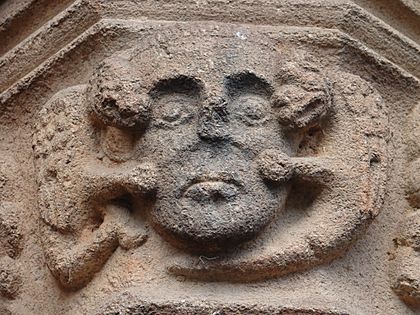 Archivo:Cabeza de condenado infernal atacada por dos diablos en forma de dragones