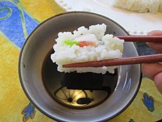 Archivo:Showing how to dip a piece of sushi into a bowl of soy sauce