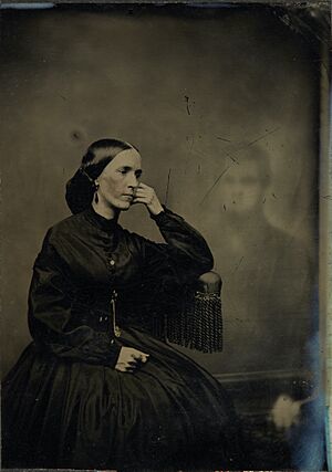 Archivo:Spirit photograph of a woman with a hand on her face with an image of a man in the background (1865)