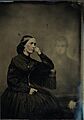 Spirit photograph of a woman with a hand on her face with an image of a man in the background (1865)