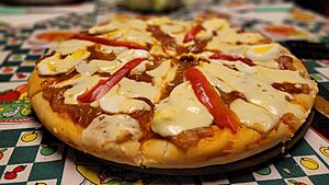 Archivo:Pizza casera con mozzarella, morrón rojo, huevos, cebollas y salsa de tomates