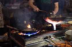 Archivo:Wok cooking and fire by romainguy