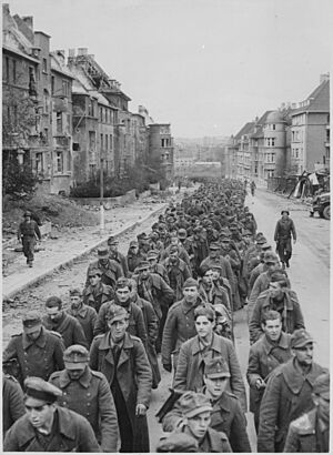 Archivo:"The endless procession of German prisoners captured with the fall of Aachen marching through the ruined city streets to - NARA - 541597