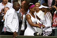 Archivo:Serena Williams embraces Venus Williams as Father looks on