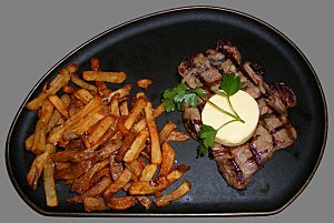 Archivo:Sirloin steak with garlic butter and french fries cropped