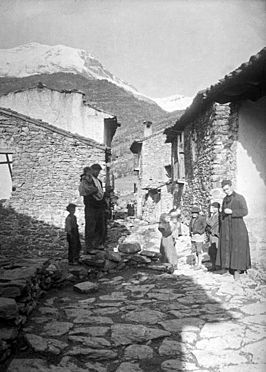 Home, dona i nens en un carrer de Barbaruéns amb una muntanya nevada al fons (cropped).jpeg