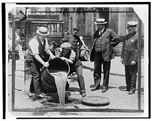 Archivo:New York City Deputy Police Commissioner John A. Leach, right, watching agents pour liquor into sewer following a raid during the height of prohibition LCCN99405169