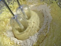 Archivo:Beating flour into cake mixture