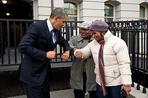 Archivo:Barack Obama bumps elbows with women in the street