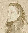 Fotografía sepia que muestra la cara y los hombros de una mujer que lleva un velo sobre su pelo