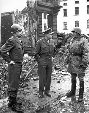 Archivo:General Omar Bradley, General Dwight Eisenhower, and General George Patton, all graduates of West Point, survey war damage in Bastogne, Belgium. 1944-1945