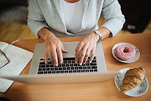 Archivo:Woman typing on the laptop. One tray with a donut and one tray with a croissant next to her - 51524764031