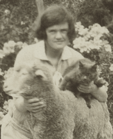 Alison Ashby with a cat and pet lamb in Wittunga farm garden.png