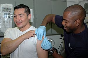 Archivo:US Navy 091129-N-8960W-064 Hospital Corpsman Michael Parke gives a vaccine to Lt. Carlos Lopez aboard the aircraft carrier USS Nimitz (CVN 68)