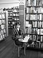 College student seated and reading inside City Lights bookstore