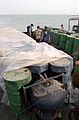US Navy 030321-N-4655M-029 Coalition Navy Explosive Ordnance Disposal (EOD) team members inspect camouflaged mines hidden inside oil barrels on the deck of an Iraqi shipping barge