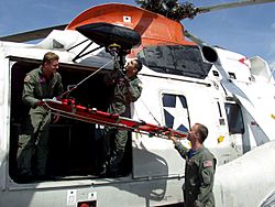 Archivo:US Navy 040525-N-6639C-015 Hospital Corpsman 3rd Class Christopher Sandoval connects a rescue litter to the hoist of an UH-3H Sea King
