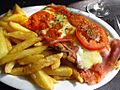 Milanesa napolitana con papas fritas rodajas de tomate y orégano
