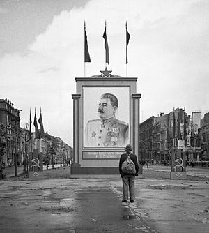 Archivo:A German civilian looks at a large poster portrait of Stalin on the Unter-den-Linden in Berlin, 3 June 1945. BU8572
