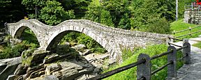 Puente de arco de piedra sobre un río.