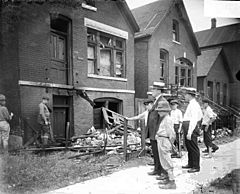 Archivo:Chicago race riot, white men, boys standing in front of vandalized house