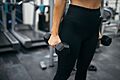 Close up of a woman holding two dumbbells in her hands - 50431900038