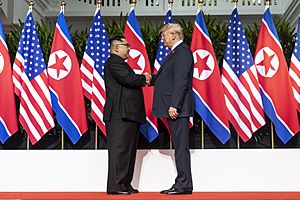 Archivo:Kim and Trump shaking hands at the red carpet during the DPRK–USA Singapore Summit