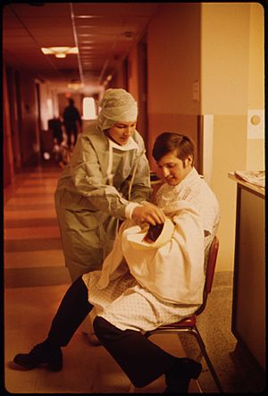 A NEW FATHER HOLDS HIS CHILD FOR THE FIRST TIME IN LORETTO HOSPITAL IN NEW ULM, MINNESOTA. THERE ARE TWO HOSPITALS IN... - NARA - 558171.jpg
