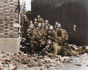 Archivo:Japanese Special Naval Landing Forces holding a position behind the corner of a building with a Type 11 light machine gun, equipped with Type 99 gas masks, in Shanghai, China, August-November 1937. (37598977682)