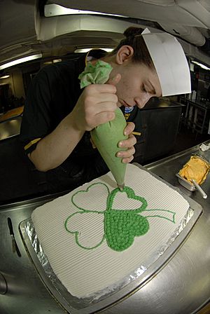 Archivo:US Navy 090317-N-2475A-043 Culinary Specialist 3rd Class Rechele Rosposa, from Bremerton, Wash., decorates a Saint Patrick's Day cake in the ship's bake shop aboard the aircraft carrier USS John C. Stennis (CVN 74)