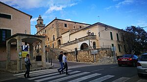 Archivo:Carretera de la Ciutat amb pou i biblioteca a Lloret de Vistalegre amb campanar al fons