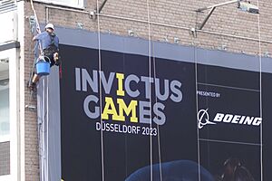 Archivo:Invictus Games in Düsseldorf, Fassadenkletterer bei der Installation eines Großplakats, 22. August 2023 (1)