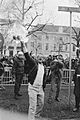 Man met brandend boek en daarachter iemand van de Mobiele Eenheid en een fotogra, Bestanddeelnr 934-4146