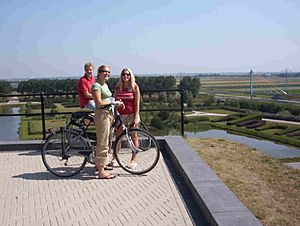 Archivo:FileCyclists enjoy the view from the top of Spotter's hill, a 40 meter high manmade hill in the Haarlemmermeersebos